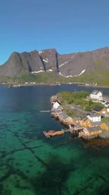 Norveç 'in Lofoten Adaları, Norveç' in Sakrisoy, Norveç, İskandinavya 'nın tarihi köyünde geleneksel sarı balıkçı Rorbuer kulübeleriyle Lofoten Adaları manzarası