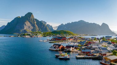 Norveç 'in güzel bir kıyı köyü, yüksek dağlarla çevrili, fiyordun sakin sularında kırmızı çatılı evler ve tekneler sergileniyor. Reine, Lofoten, Norveç