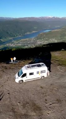 Aşağıdaki göl ve vadi manzaralı bir dağda park etmiş bir karavan. Açık hava maceraları için mükemmel. Vagavatnet, Lalm, Norveç