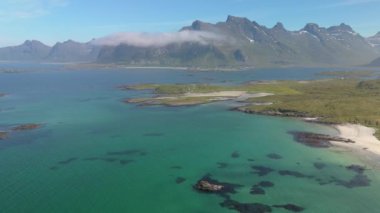 Kristal berraklığında suları, kumlu plajları ve yüksek dağları olan sakin kıyı manzarası. Lofoten Norveç