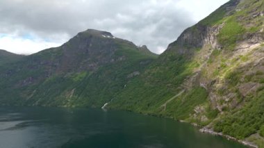Çarpıcı manzara, yüksek dağlar, sakin göl, yemyeşil, bulutlu gökyüzü, sakin ve pitoresk manzara, Geiranger, Norveç