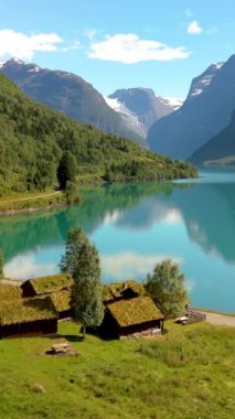 Bereketli yeşillik ve çarpıcı manzaralı geleneksel kamaralarla çevrili sakin dağ gölü. Lovatnet, Norveç