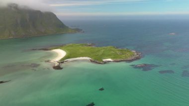 Norveç 'te berrak turkuaz sular ve yeşil tepelerle çarpıcı bir kıyı manzarası yakalayan hava manzarası. Lofoten Norveç