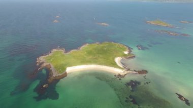 Kristal berrak mavi sular ve el değmemiş kumsallarla çevrili huzurlu bir adanın nefes kesici insansız hava aracı görüntüleri. Lofoten Norveç