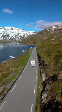 Göl kenarındaki karlı yolda kamp aracı keşif ve rahatlama için mükemmel dağlarla Langvatnet, Geiranger, Norveç