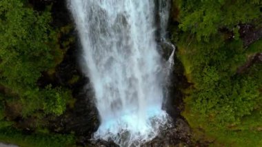 Sersemletici bir şelale şelalesi şelaleden düşüyor. Etrafı bereketli yeşilliklerle çevrili, sakin bir doğal ortamda. Fjaerlandsfjorden, Fjord, Vestland, Norveç