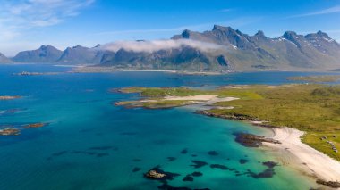 Kolbedeliden Sahili, Lofoten, Norveç 'in Lofoten Adaları' nın engebeli güzelliği kristal berrak turkuaz sularıyla el değmemiş beyaz bir kumsalda, berrak mavi bir gökyüzünün altında..