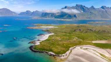 Yeşil tepeleri, el değmemiş kumlu plajları ve gökyüzüne uzanan yüksek dağları olan sakin bir Norveç kıyısı. Kolbedeliden Sahili, Lofoten