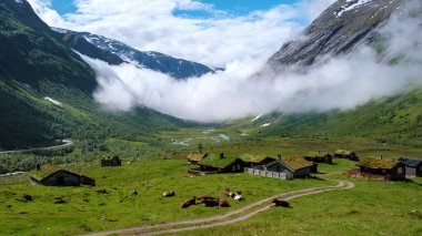 Bereketli çayırlar, rahat kulübeler, karlı dağların altındaki toprak yollar. Bulutlar sürükleniyor, büyülü bir sisli atmosfer yaratıyor.