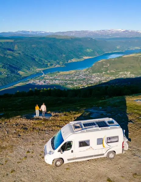 Bir çift, manzaraya tepeden bakan bir tepede parkedilmiş karavanlarından Norveçli fiyort manzarasının keyfini çıkarıyor. Grimsdalen Norveç