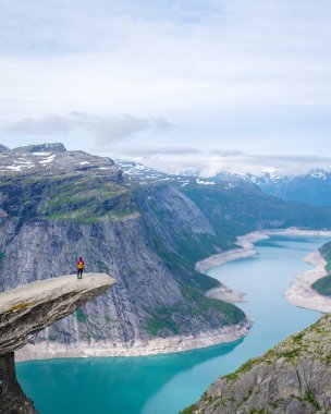 Norveç 'in Trolltunga kentinde yalnız bir yürüyüşçü duruyor. Norveç' te turkuaz bir fiyorda tepeden bakan dramatik bir uçurum. Manzaranın enginliği nefes kesici..