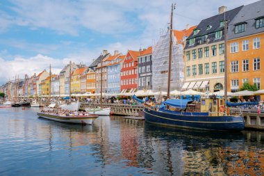 Kopenhag Danimarka 21 Temmuz 2024, Kopenhag, Danimarka 'da renkli binalar ve diğer gemilerden geçen yolcularla dolu bir tekne..