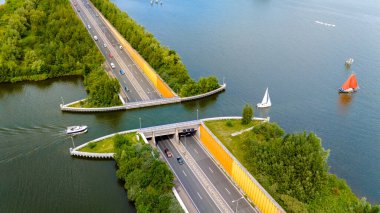 Hollanda 'daki Aquaduct Veluwemeer' in hava görüntüsü hem yol hem de su trafiğine olanak sağlayan eşsiz tasarımını sergiliyor. # Yelkenli tekneler bir otobanın üzerinden su yoluyla geçiyor #