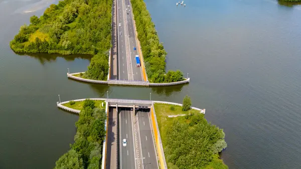 stock image An aerial view captures the unique Veluwemeer Aquaduct in the Netherlands. This impressive structure allows vehicles to pass through the water, creating a stunning visual effect.