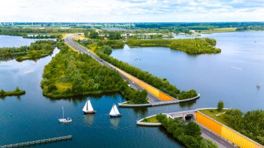 Hollanda 'daki Veluwemeer Aquaduct' un hava görüntüsü, su yolunu ikiye bölerken benzersiz tasarımını sergiliyor, botların otoyol üzerinde ilerlemesine izin veriyor.