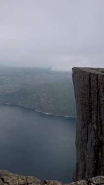 Norveç 'in önceki bölümlerinde, sakin bir göle yolculuk uçurum manzarası ile başlar, göl manzarasına geçiş, nefes kesen bir uçurum manzarası, doğa güzelliği, Preikestolen Norveç