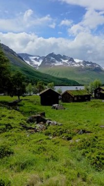 Yeşil tarlaları, manzaralı gölü ve doğa güzellikleriyle dolu büyüleyici evleri olan bir dağ köyünü gösteren sakin bir video. Norveç 'teki iç innerdalen vadisinde sakin ve huzurlu bir ortam var.