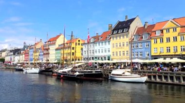 Kopenhag Danimarka 10 Temmuz 2024, Rıhtım manzaralı, renkli binalar ve tekneler ile şehir keşfi için ideal bir yer. Gökyüzü ve su manzarayı güzelleştiriyor, Nyhavn.