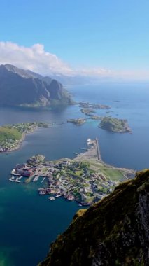 Dağlar ve suyla çevrili bir adada büyüleyici küçük bir kasaba güzel bir şekilde hava görüntüsüyle çekiliyor. Huzurlu ve manzaralı bir ortam yayıyor. Reinebringen Lofoten Norveç