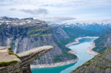 Norveç 'teki dolambaçlı bir fiyordun çarpıcı görüntüsü, Trolltunga' nın kıyısından, düz bir tepesi olan devasa bir uçurum..