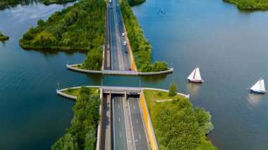 Hollanda 'daki Veluwemeer Aquaduct' un hava görüntüsü, çevredeki manzaraya pürüzsüz bir şekilde entegre edilmiş otoban köprüsünü gösteriyor.