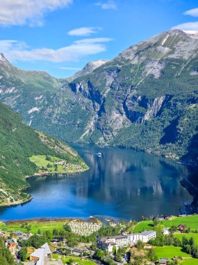 Norveç 'te sakin bir fiyort, yüksek dağları, yemyeşil yeşillikleri ve deniz kenarındaki büyüleyici bir köyü yansıtır. Norveç 'in Geiranger' si 
