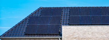 Güneş panelleri parlak güneşin altında parıldıyor, stratejik olarak çağdaş bir çatıya yerleştiriliyor, sürdürülebilir yaşam için yenilenebilir enerji yakalıyor. Zonnepanelen, Zonne Energie, Çeviri: Güneş Paneli, Güneş Enerjisi