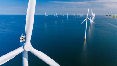 Şiddetli rüzgar türbinleri, Hollanda 'da rüzgar enerjisini yakalayıp sürdürülebilir enerji üretimine katkıda bulunan denizde dimdik dururlar..