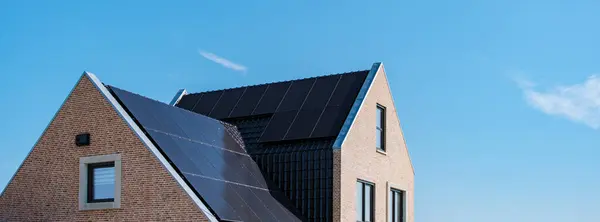 stock image solar panels on a home house roof, harnessing sun energy against a vibrant sky, reflecting sustainable living in the Netherlands, Zonnepanelen, Zonne energie, Translation: Solar panel, Sun Energy