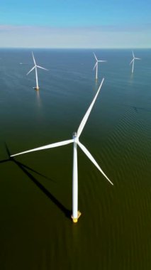 Nefes kesici bir hava perspektifi, bugün Hollanda 'da kullanılan keskin dişli yenilenebilir enerji teknolojisini vurgulayan su üzerinde bulunan dikkate değer rüzgar türbinlerini sergiliyor.