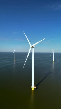 Hollanda 'daki sürdürülebilir enerjinin yenilikçi geleceğini sembolize eden, su yüzeyine yerleştirilmiş sayısız rüzgar değirmeni ve türbini yakalayan nefes kesici bir hava manzarası.