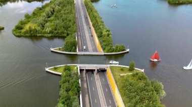 Hollanda 'daki su kemeri Veluwemeer çarpıcı bir hava manzarası sunuyor, bir otoyol ve su yolunun kesişimini gösteriyor, etkileyici mühendisliğini ve yenilikçi tasarımını vurguluyor.