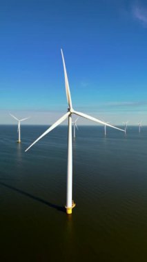 Kesinlikle çarpıcı bir hava manzarası, güzel Hollanda suları arasında özenle temiz, yeşil enerji üreten yel değirmeni türbinlerinin etkileyici görüntüsünü yakalıyor.