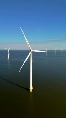 Bu çarpıcı bir hava görüntüsü. Rüzgâr türbinleri muhteşem bir şekilde okyanusun üzerinde duruyor. Hollanda 'da yenilenebilir enerjiyi ustalıkla yakalıyorlar.
