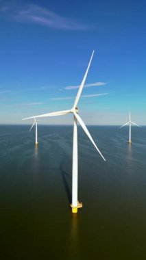 Hollanda 'da gerçekleşen etkileyici yenilenebilir yeşil enerji çabalarını gözler önüne seren çok sayıda yel değirmeni türbininin göz kamaştırıcı bir görüntüsü.