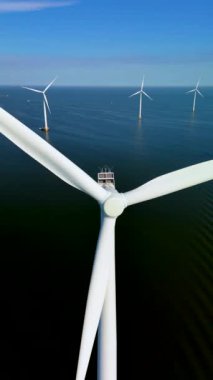 Bu hava görüntüsü, sakin sulara karşı sersemletici yel değirmenleri ve türbinleri barındırıyor. Hollanda 'nın yeşil enerjiye olan bağlılığını gösteriyor ve daha çevre dostu bir geleceğe giden yolu açıyor.