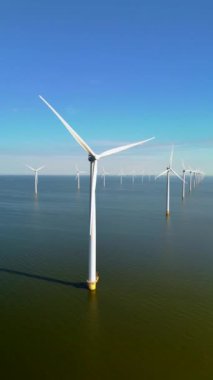 Bir hava görüntüsü Hollanda 'daki görkemli rüzgar türbinlerini gösteriyor, yenilenebilir enerjiyi kullanıyorlar ve çevreye ve yerel topluluklara faydası olan sürdürülebilir uygulamaları destekliyorlar.