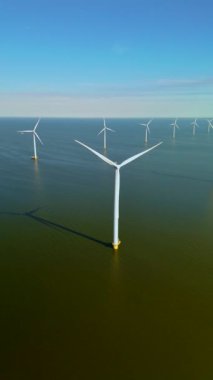 Bu hava görüntüsünde, Hollanda 'da yenilenebilir enerji üreten rüzgar değirmenleri ve türbinler, sürdürülebilirlik ve yenilikçi enerji uygulamalarına yönelik bölgelerin kararlılığını vurguluyor
