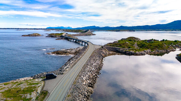 A stunning coastal route winds its way across rocky terrain, linking little islands surrounded by tranquil waters in Norway. Atlantic ocean road Norway