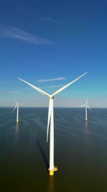 Havadan bakıldığında, Hollanda 'da temiz ve yenilenebilir enerji üreten çok sayıda yel değirmeni ve türbin görülüyor ve canlı doğal ortamdaki yenilikçi sürdürülebilir uygulamaları vurguluyorlar.