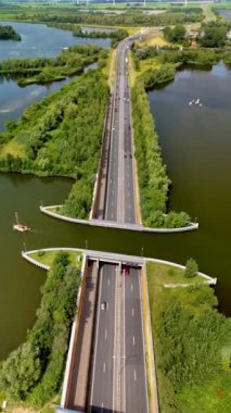 Hollanda 'daki Aqueduct Veluwemeer ile hareketli bir otoyolun sakin bir su yolu ile birleştiği ve benzersiz ve yenilikçi bir tasarım oluşturduğu yer arasındaki pitoresk buluşma noktasını deneyin.
