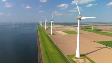 Hollanda 'daki yel değirmeni türbinlerinin görünümü sürdürülebilir enerjiye geçişi ve küresel ısınmaya karşı mücadeleyi sembolize ediyor, yenilenebilir enerji teknolojilerindeki yenilikleri vurguluyor