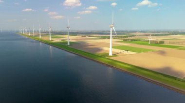 Işıldayan sular boyunca ikonik yel değirmeni türbinlerinin çarpıcı manzarasını keşfetmek, Hollanda 'nın yeşil enerjiye, sürdürülebilirliğe ve çevre yönetimine bağlılığını göstermek