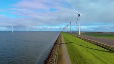 Hollanda kıyı şeridi boyunca ikonik yel değirmeni türbinlerini keşfedin. Bu hayati yapılar enerji geçişinde ve sürdürülebilir bir gelecek için küresel ısınmaya karşı mücadelemizde çok önemli.