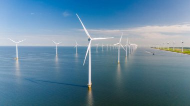 Rüzgarın gücünü kullanan dev rüzgar türbinleri Hollanda 'nın sakin sularında dimdik ayakta duruyor ve yenilenebilir enerjiyi destekliyor..