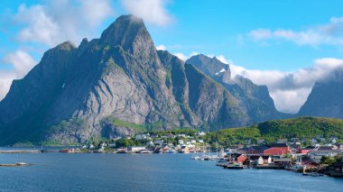 Norveç 'in Lofoten Adaları' nın kıyısında berrak mavi gökyüzünün altında büyüyen büyüleyici bir köy olarak sakin sular yükselen tepeleri yansıtır. Reine Lofoten