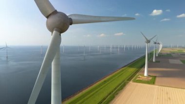 İkonik yel değirmeni türbinlerinin gelecek nesiller için güvenli bir gelecek için yeşil enerjiye ve sürdürülebilirliğe geçişi sembolize ettiği Hollanda 'nın çarpıcı manzaralarını araştırın.