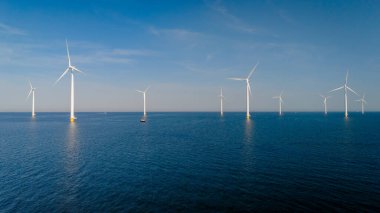 Hollanda 'da rüzgarın gücünü sessizce kullanan yel değirmenleri, Flevoland Hollanda' da rüzgar türbinleri ile okyanus manzaralı yel değirmeni parkı..