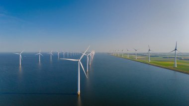 Hollanda 'nın sürdürülebilir enerji taahhüdünü yansıtan rüzgâr değirmenlerinin çarpıcı manzarası zarif bir şekilde rüzgarda dönüyor..