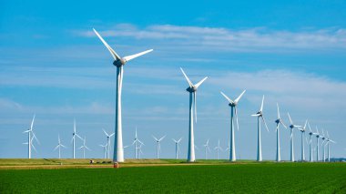 Wind turbines gracefully spin in the Dutch landscape, harnessing the power of the wind to produce clean energy under a vibrant blue sky. clipart